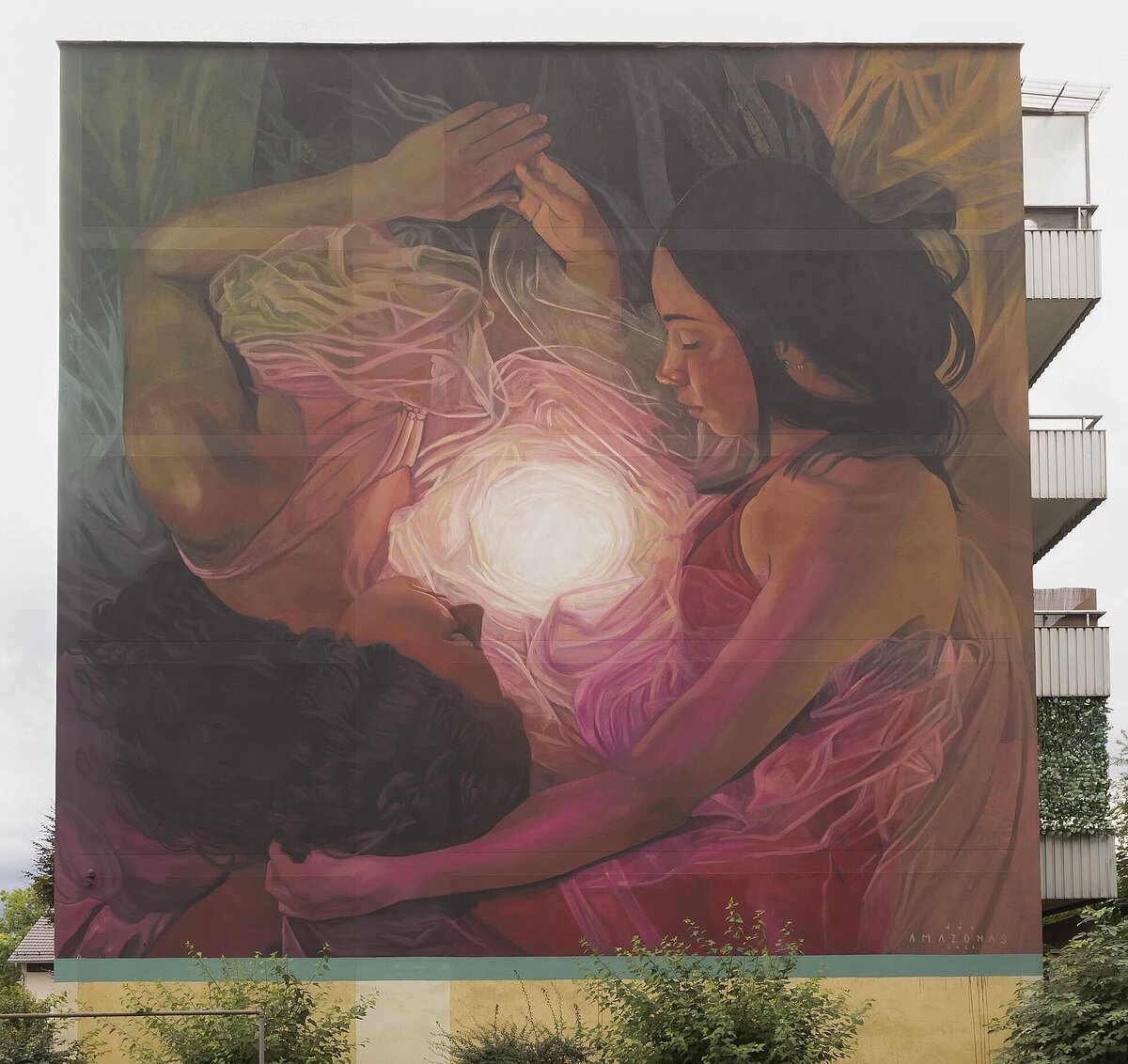 Wandkunstwerk, Personen liegen eng beieinander, in der Mitte leuchtet ein heller Lichtpunkt